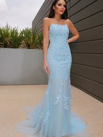 Front view of a woman wearing an elegant A-line halter lace tulle long prom gown.