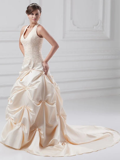 Elegant A-Line wedding dress with halter neck and chapel train.