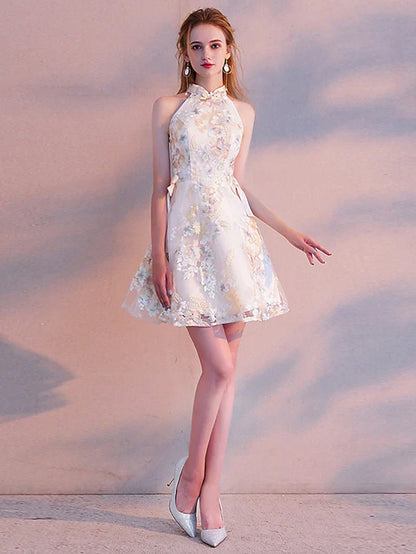 Close-up of the floral embroidery and sash ribbon on the two-piece A-line mini cocktail dress.