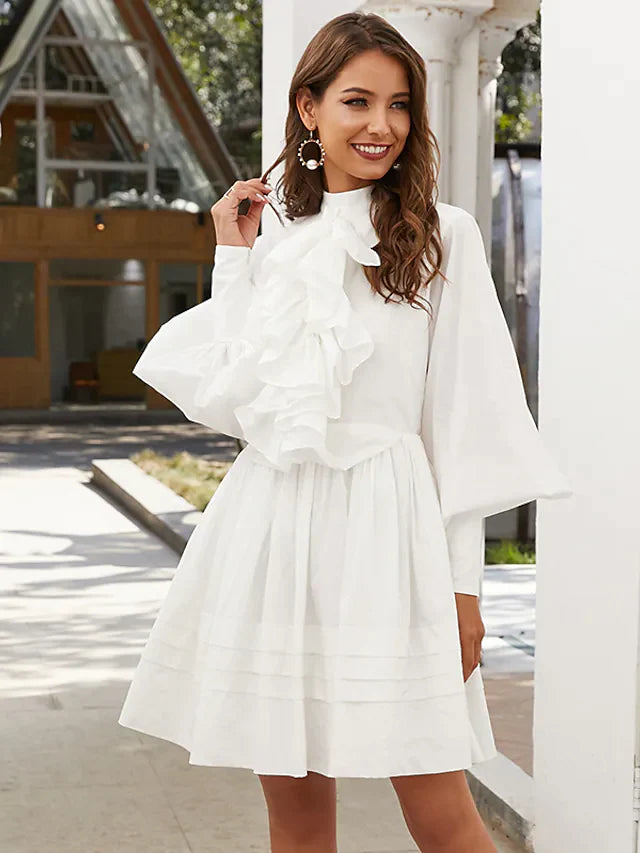 Front view of a woman in a dark A-line ruffled mini dress.