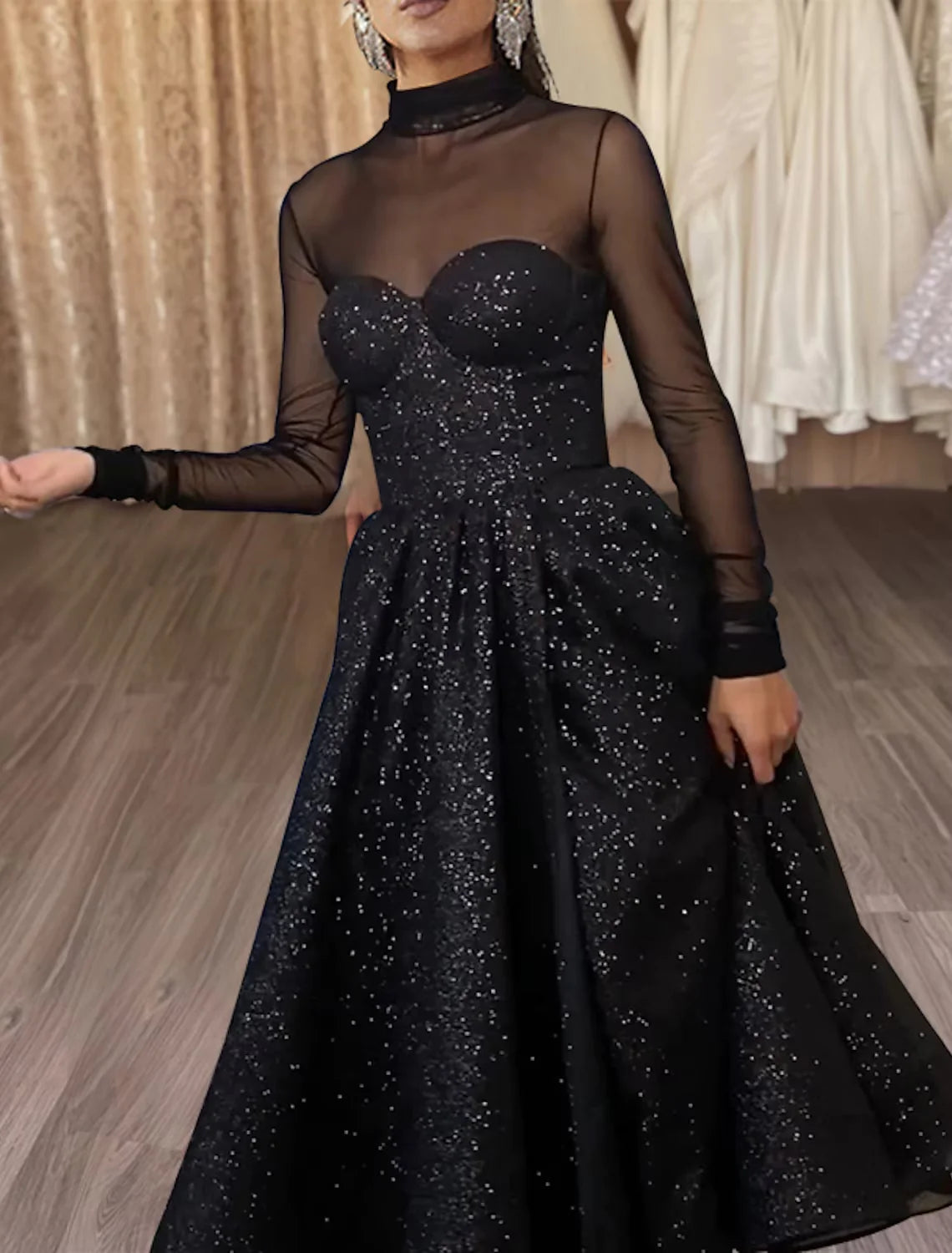 Model posing in the A-line cocktail dress, showcasing the tea-length hem and long sleeves.