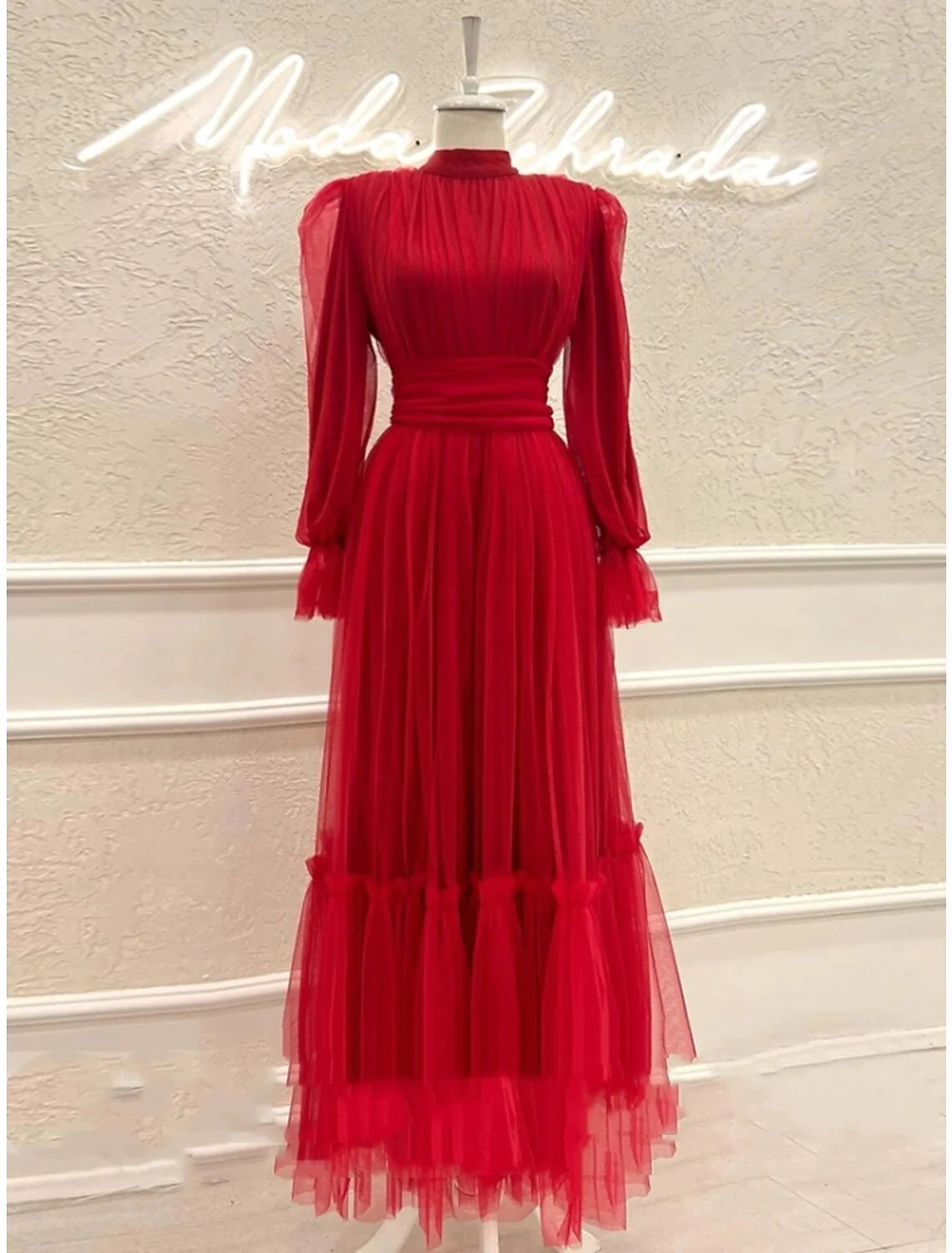 Model wearing an elegant A-line high neck long sleeve tulle prom dress with pleats and ruched details.