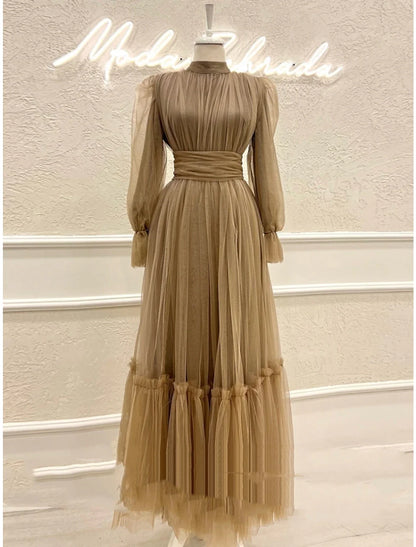 Back view of an A-line high neck long sleeve tulle formal dress with ruched details.