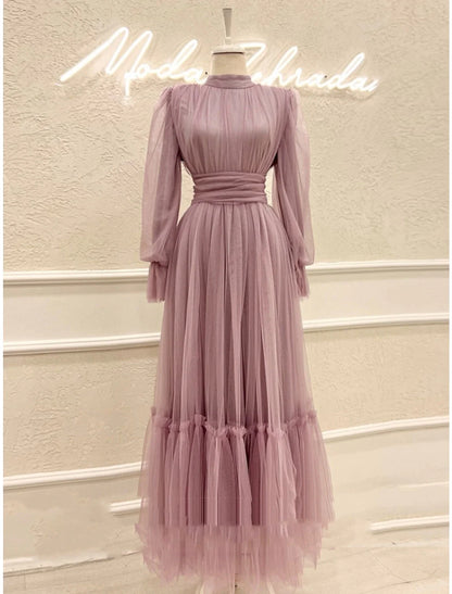 Side profile of a woman in an A-line high neck long sleeve tulle prom dress.
