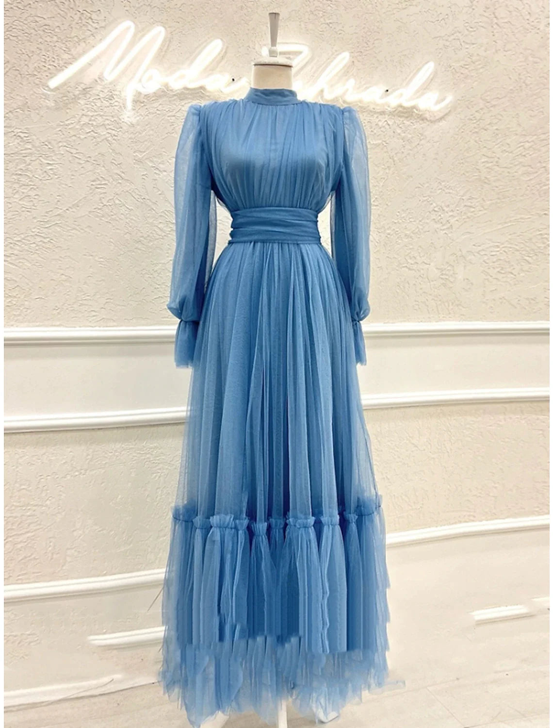 Close-up of the high neck and long sleeve details on an A-line tulle dress.