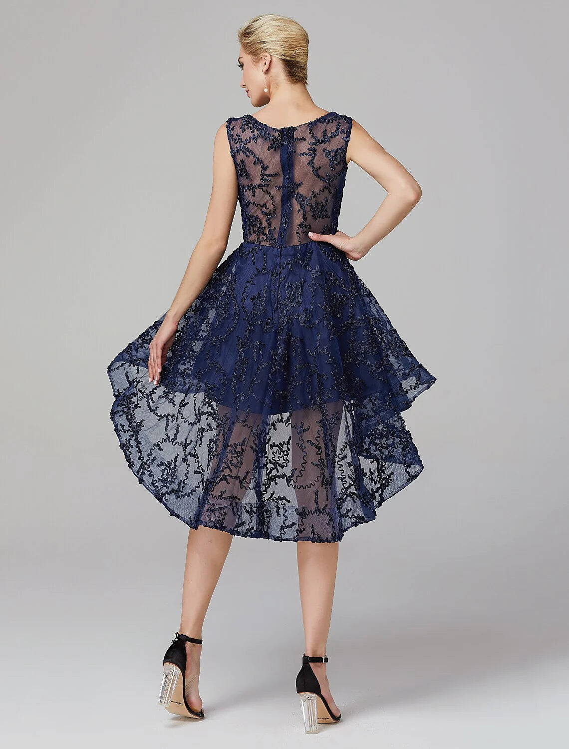 Side view of a model in a multi-color A-line illusion neck asymmetrical dress.