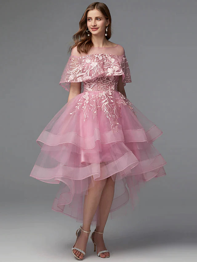 Model wearing a dark A-line high-low dress with illusion neck and lace details.