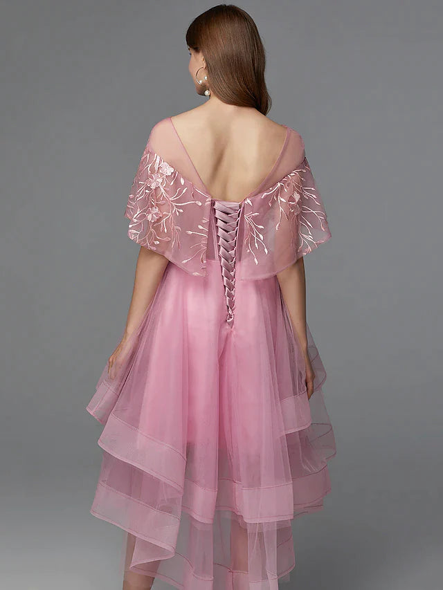 Full view of a woman in a dark high-low lace tulle dress, posing elegantly.
