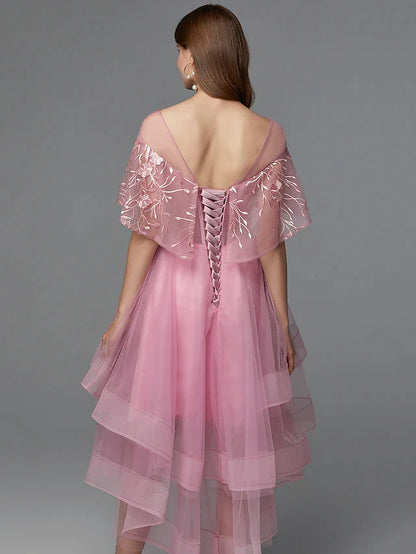 Full view of a woman in a dark high-low lace tulle dress, posing elegantly.