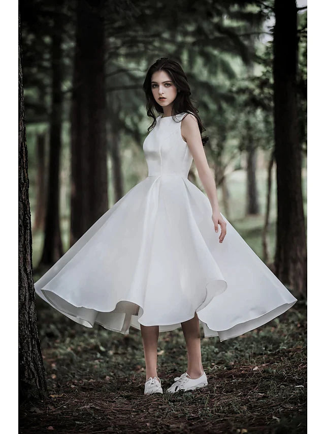 Close-up of the jewel neck and cap sleeve detail on the white A-line wedding dress.