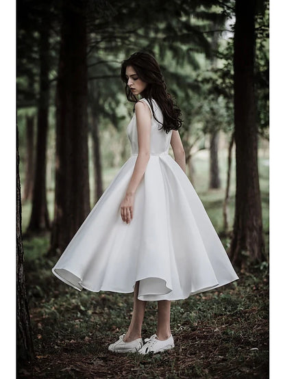 Model in the white A-line tea length wedding dress, showing movement and the chiffon over satin fabric.