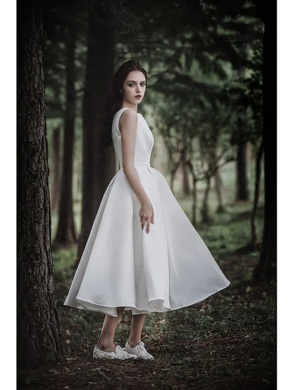 Full length view of the white A-line tea length wedding dress on a model, displaying its overall design.