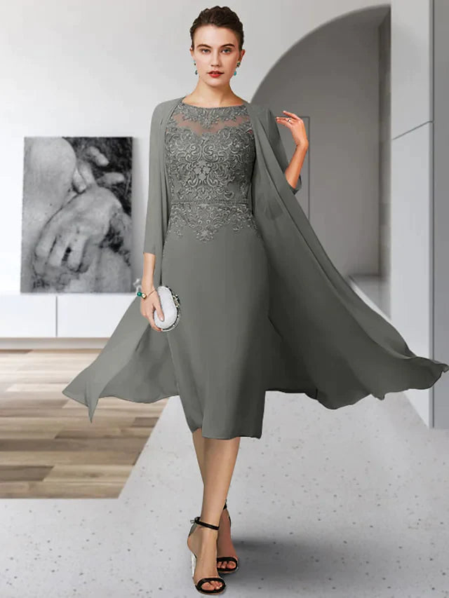 Woman wearing an elegant tea length Mother of the Bride dress with jewel neck and appliques.