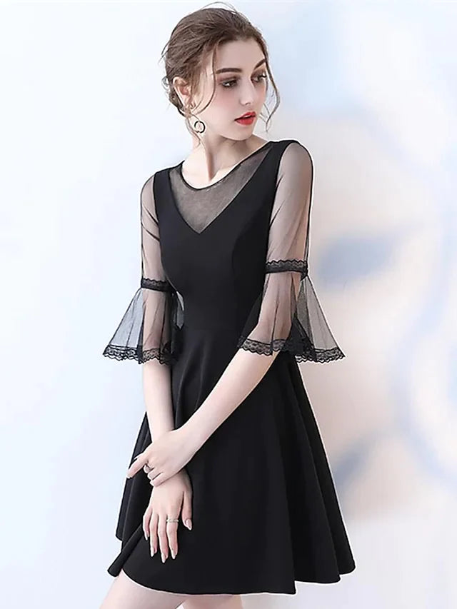 Woman wearing an elegant navy A-line jewel neck half sleeve pleated tulle knee-length cocktail dress.