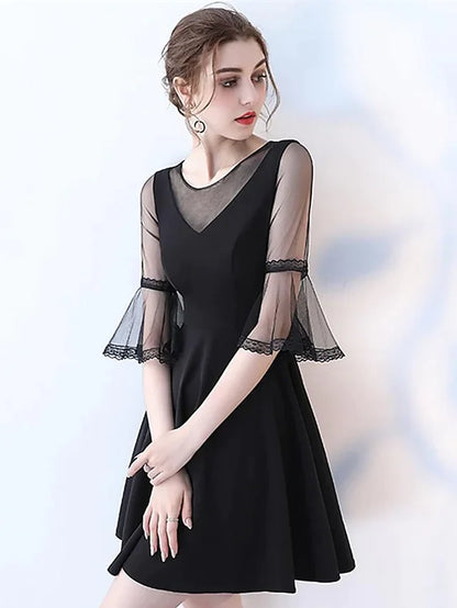 Woman wearing an elegant navy A-line jewel neck half sleeve pleated tulle knee-length cocktail dress.