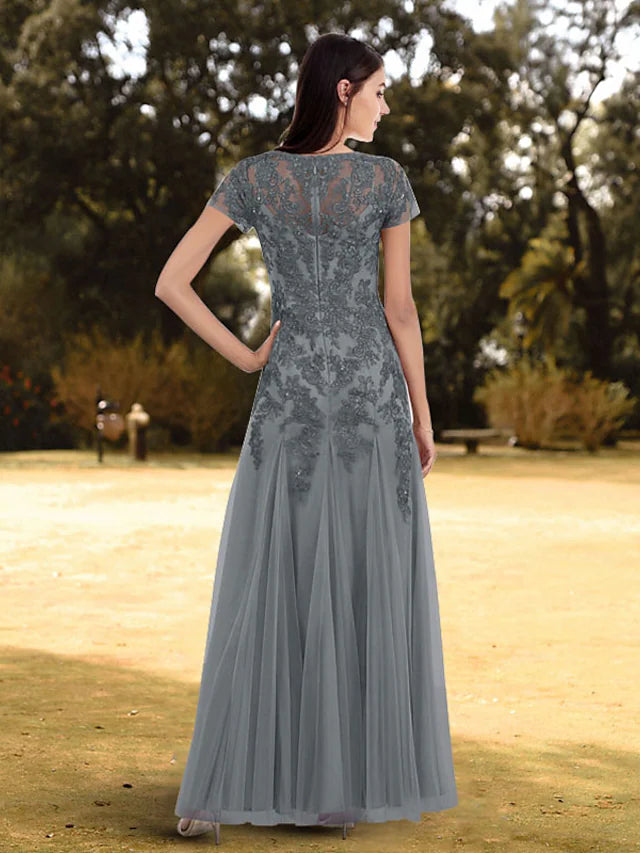 Close-up of the jewel neck and short sleeve lace detail on the elegant evening gown.