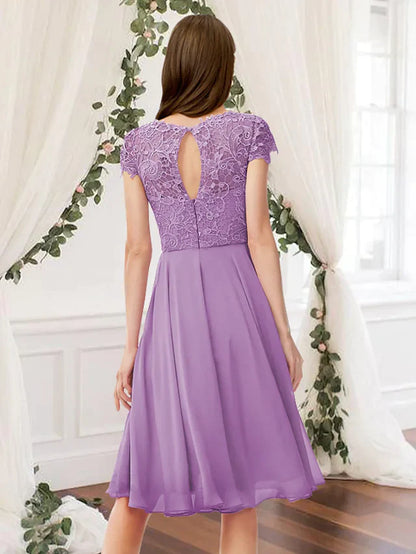 Side view of a model in an A-line jewel neck knee-length chiffon lace bridesmaid dress with pleats.