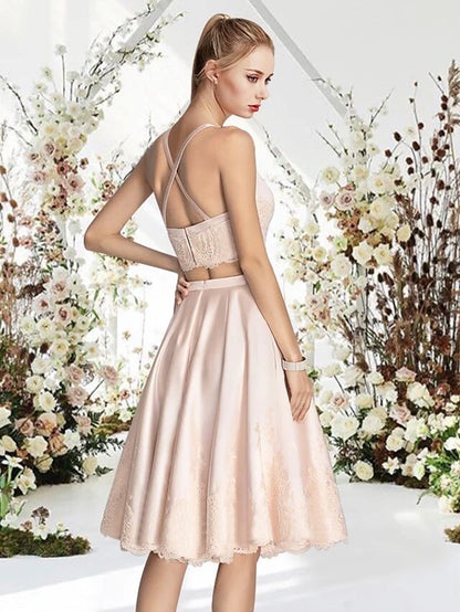 Side view of a model in a short lace and satin cocktail dress, showcasing fabric details.