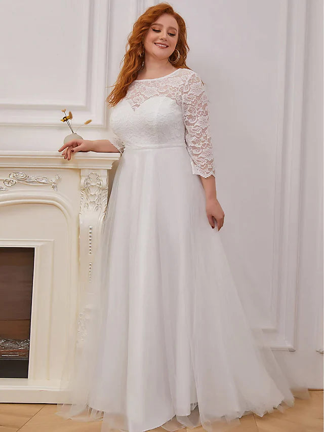 Model wearing a white A-line lace and tulle wedding dress with 3/4 sleeves.