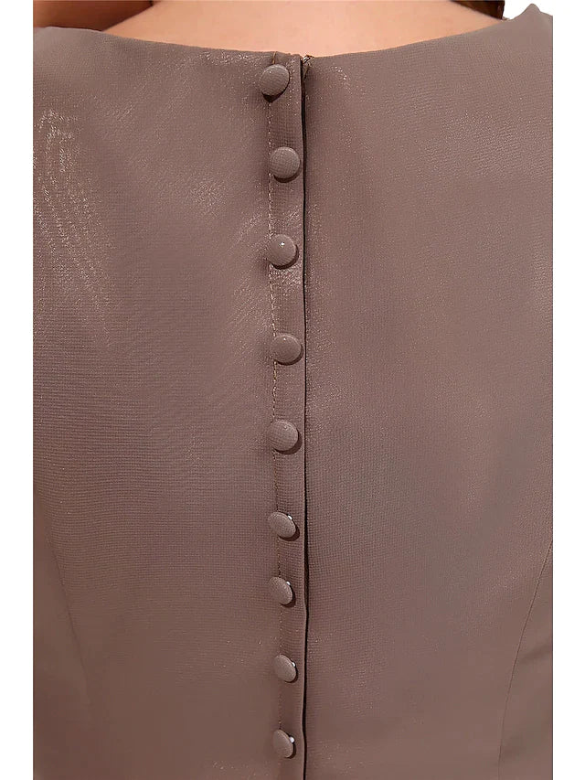 Close-up of the jewel neck and short sleeve detail on the chiffon dress.