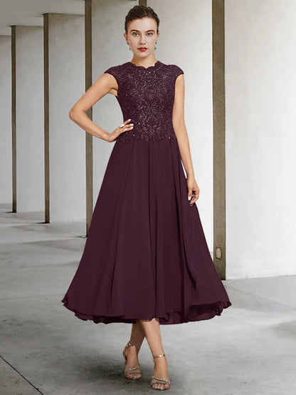 Woman wearing an elegant A-Line Mother of the Bride dress with jewel neck and lace details.