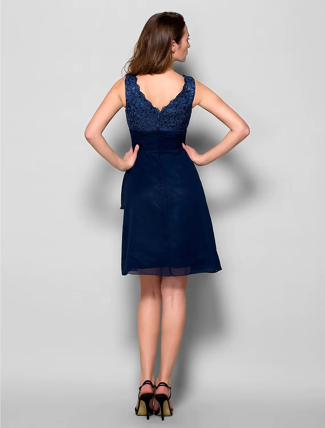 Close-up of the delicate lace bodice and sparkling crystal brooch on the light blue dress.