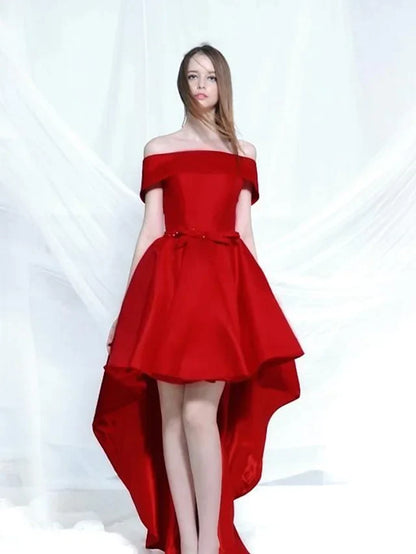 A woman wearing an elegant A-line off-shoulder satin cocktail dress with bows.