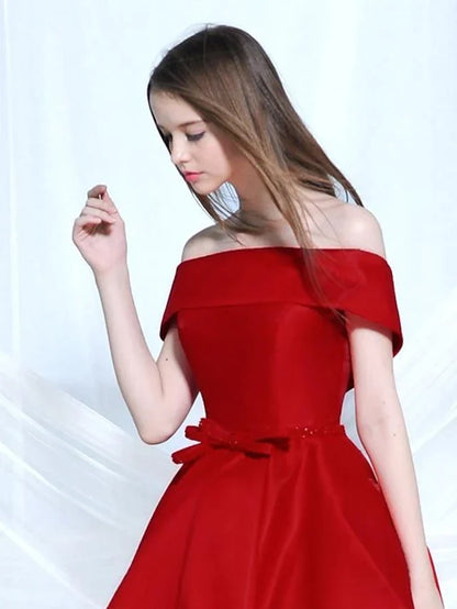 Close-up of the elegant A-line off-shoulder satin cocktail dress, highlighting the bow detail.