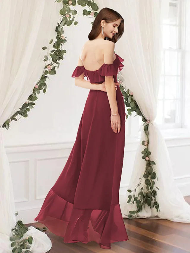 Back view of a woman wearing a dark blue A-Line off-shoulder bridesmaid dress with ruffle details.