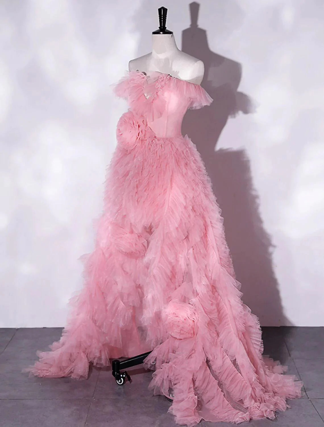 Side view of a woman in an elegant A-line floral tulle dress, highlighting the off-shoulder design.