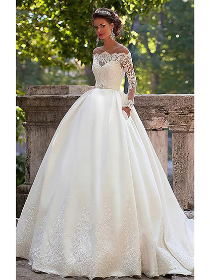 Bride wearing an elegant A-line off-shoulder lace wedding dress with long illusion sleeves and a court train.