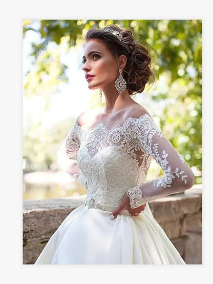 A bride in an A-line off-shoulder lace long sleeve wedding dress, viewed from the back, showing the court train.
