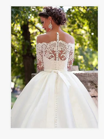 Close-up of the lace detail on the long sleeve and off-shoulder neckline of the wedding dress.