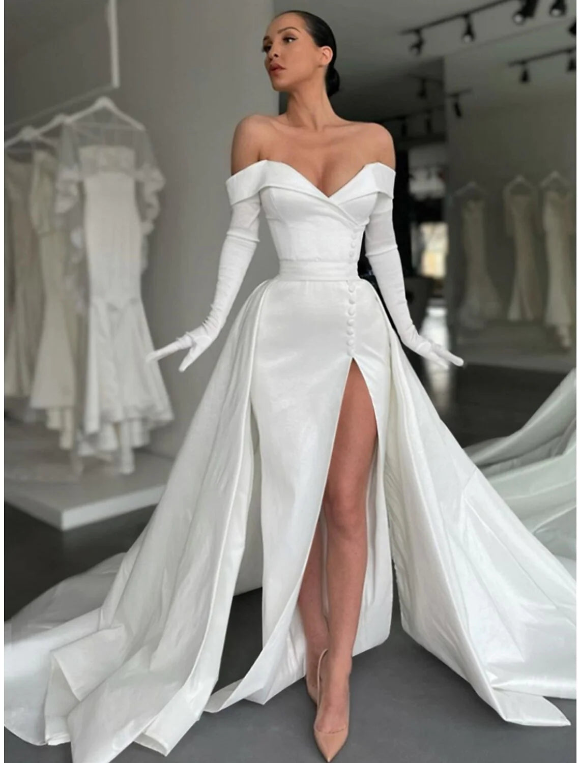 Close-up of the off-shoulder neckline and long sleeves of the formal satin gown.