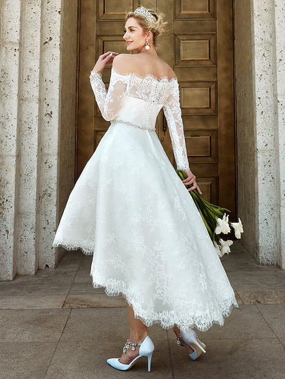 Close-up of the off-shoulder neckline and illusion lace sleeve of the wedding dress.