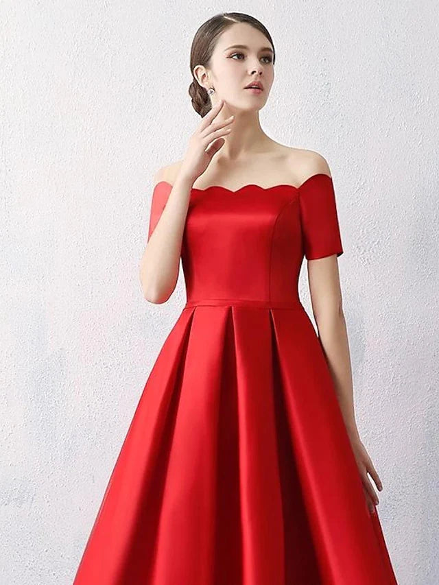 Side view of a woman in a short-sleeve off-shoulder satin dress.
