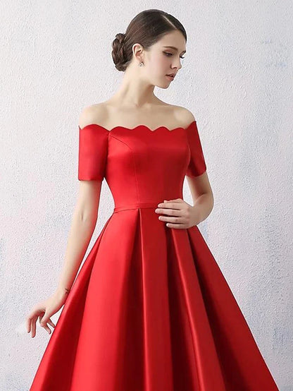 Close-up of the satin fabric and off-shoulder detail of the dress.