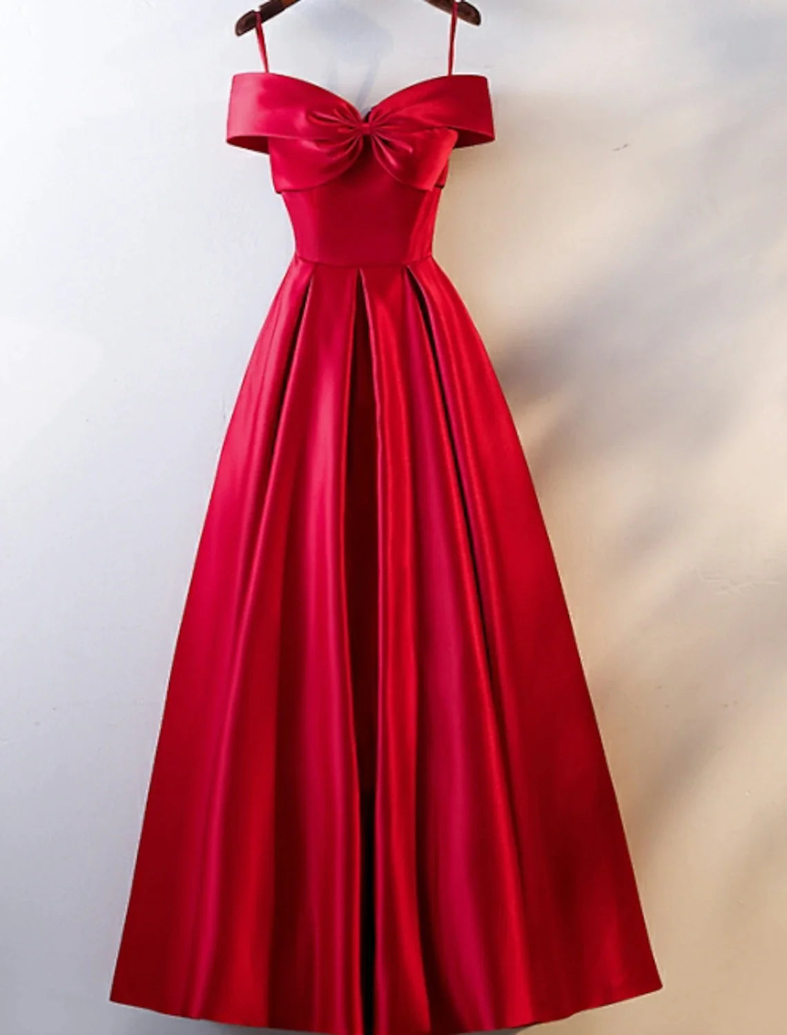 Model wearing a floor-length A-line off-shoulder satin prom dress with an open back.