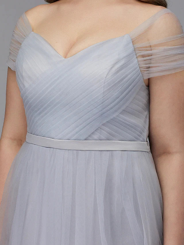 Close-up of the back of the light-colored tulle dress, highlighting the criss-cross detail.