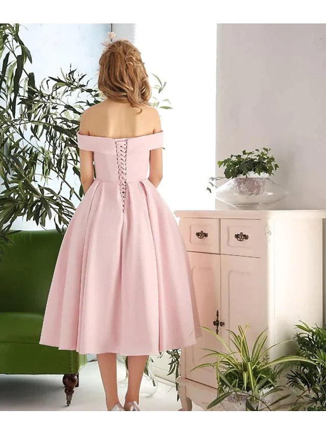 Back view of a woman showcasing the pleats on an A-line cocktail dress.