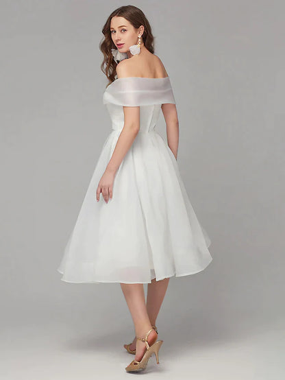 Close-up of the off-shoulder neckline and intricate criss-cross pleats on the white organza dress.