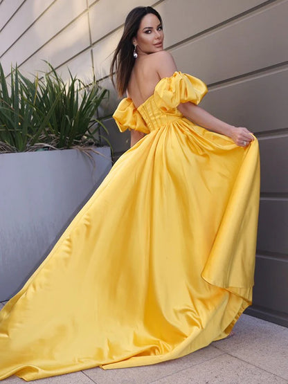 Side view of a yellow satin A-line prom dress with off-the-shoulder design.