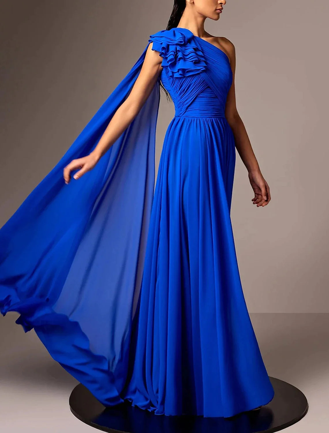 Model wearing an elegant A-line one-shoulder chiffon evening gown with pleats and a ruched flower.