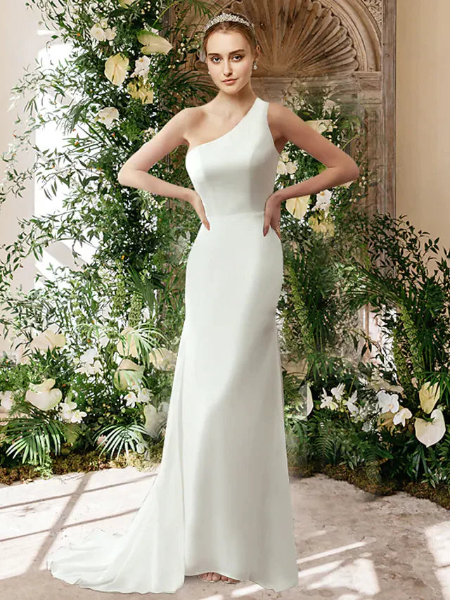 Woman wearing an elegant white one-shoulder chiffon wedding dress.