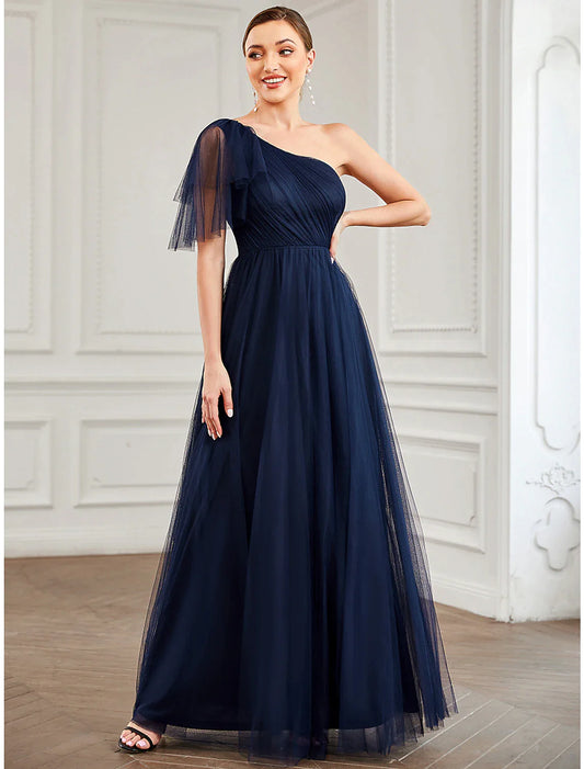 Woman wearing a light blue A-line one-shoulder tulle gown with a floral detail on the shoulder.