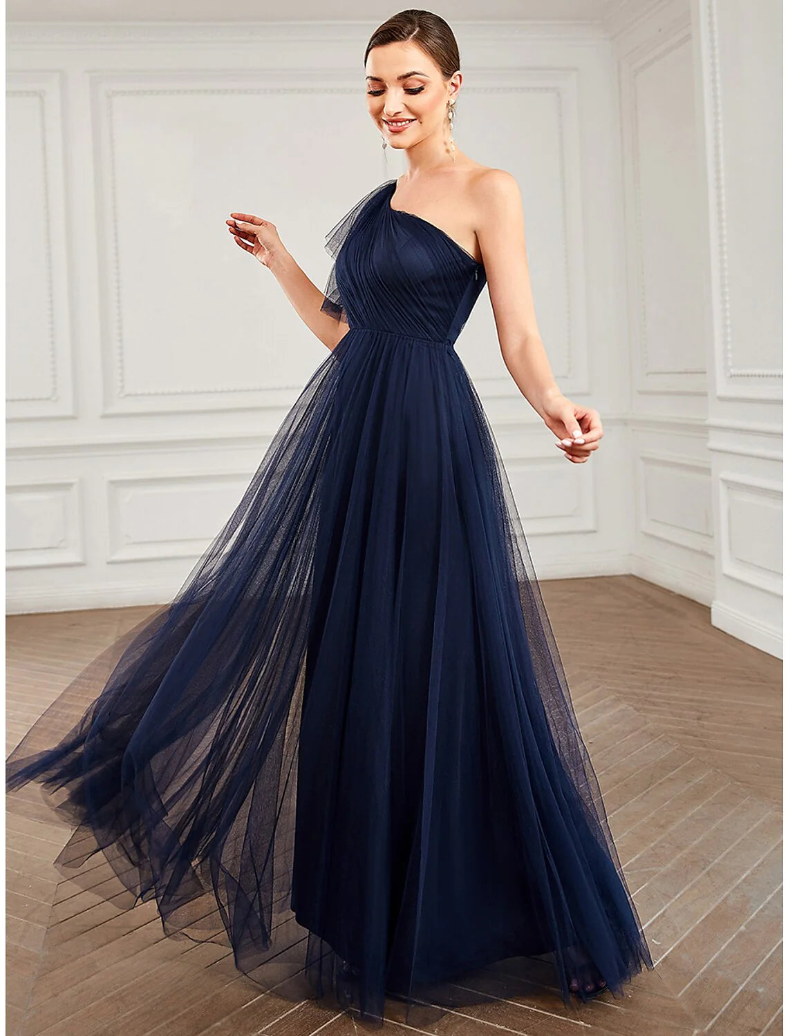 Close-up of the one-shoulder neckline and floral applique on the light blue tulle dress.