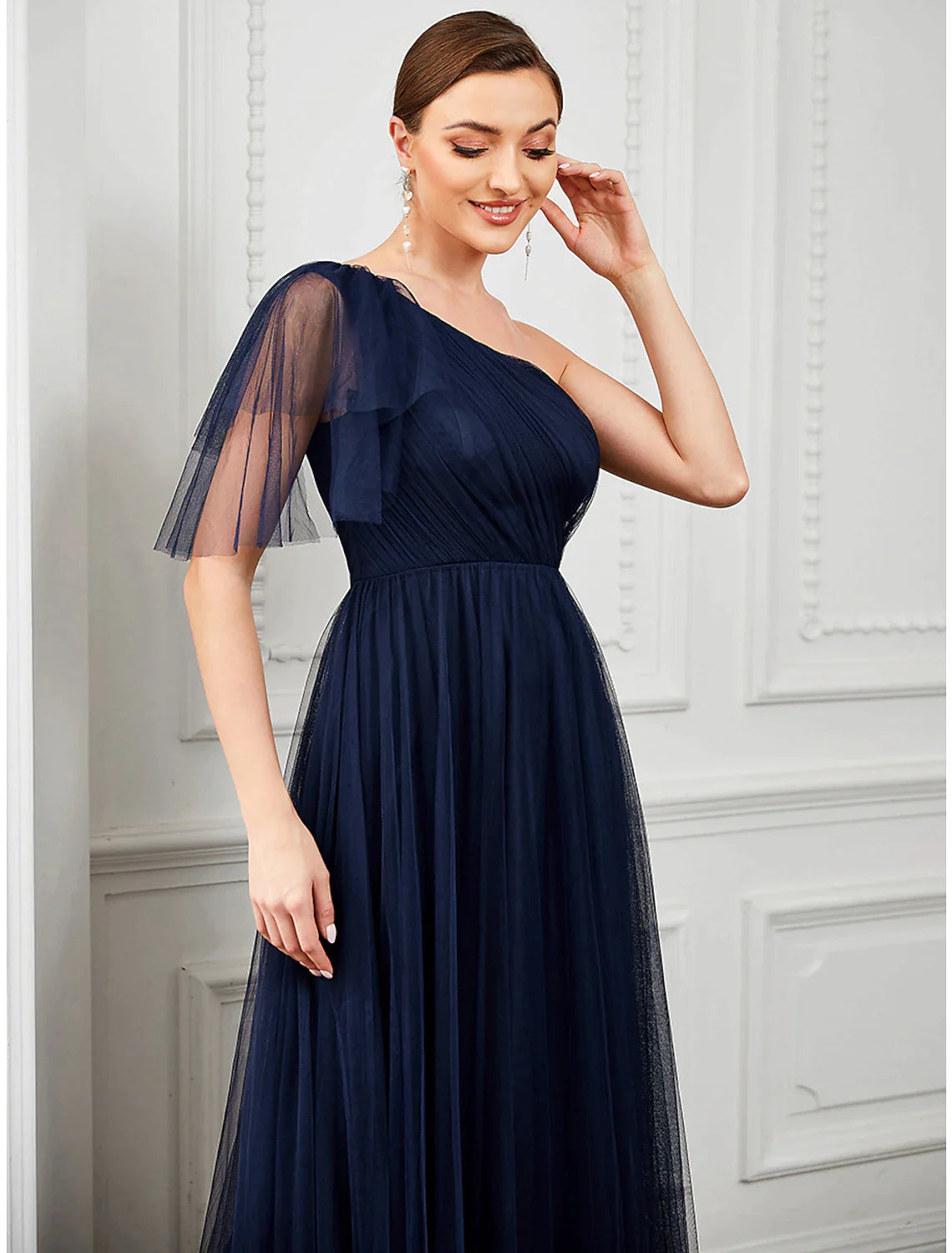 Woman posing gracefully in the light blue A-line one-shoulder tulle gown.
