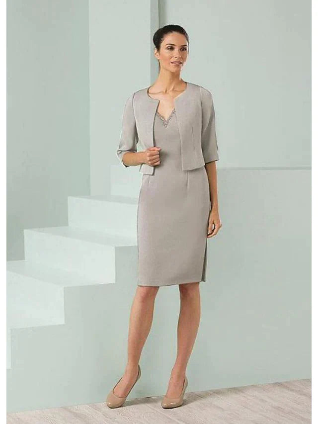 Elegant satin Mother of the Bride dress with plunging neck, half sleeves, and beading, worn with a matching wrap.