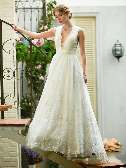 Bride in elegant A-line wedding dress with plunging lace neckline.