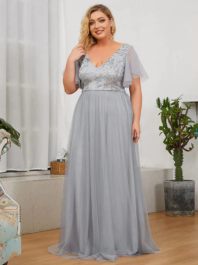 Plus size woman wearing a blush A-line sequined bridesmaid dress with a plunging neckline.